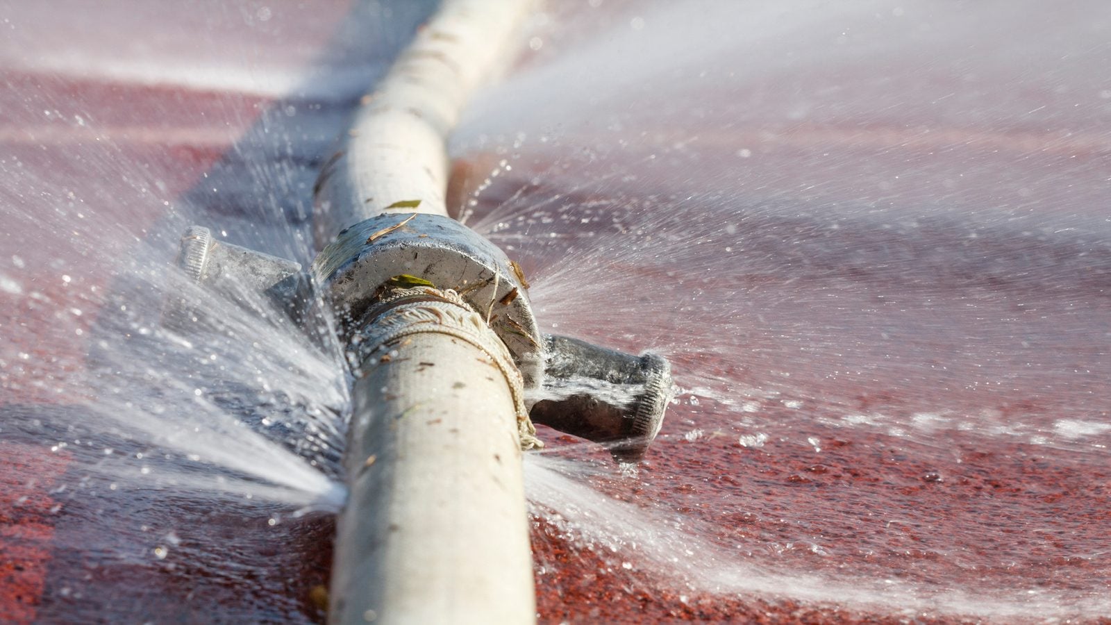 Water spraying from a leaking pipe onto the floor